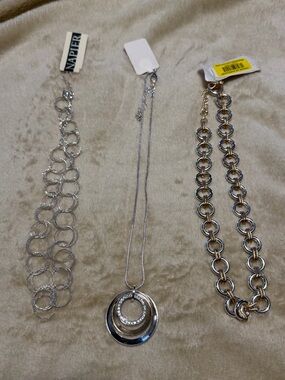 Three necklaces; one silver and two with silver and gold.